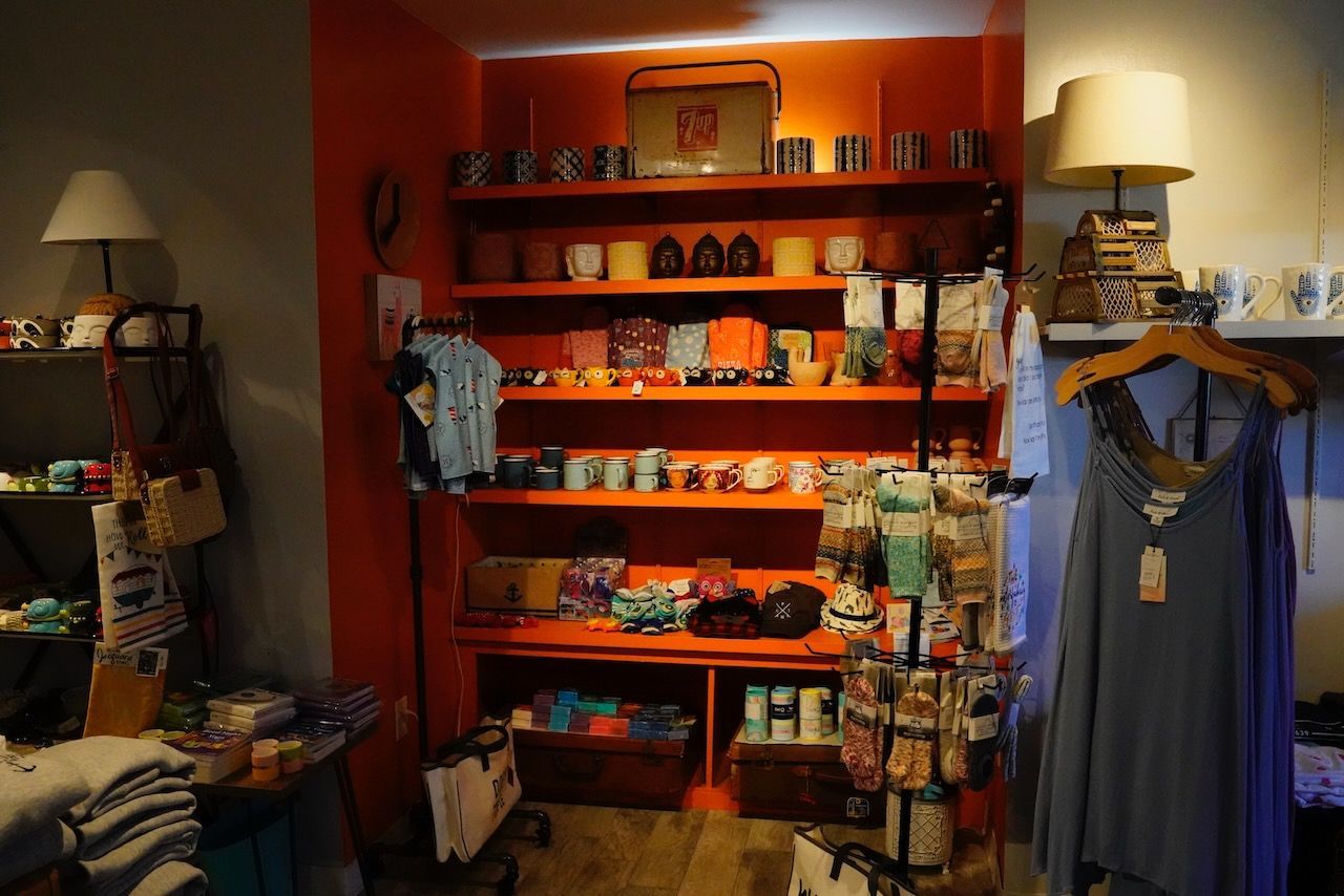 A store with a lot of shelves and clothes on hangers