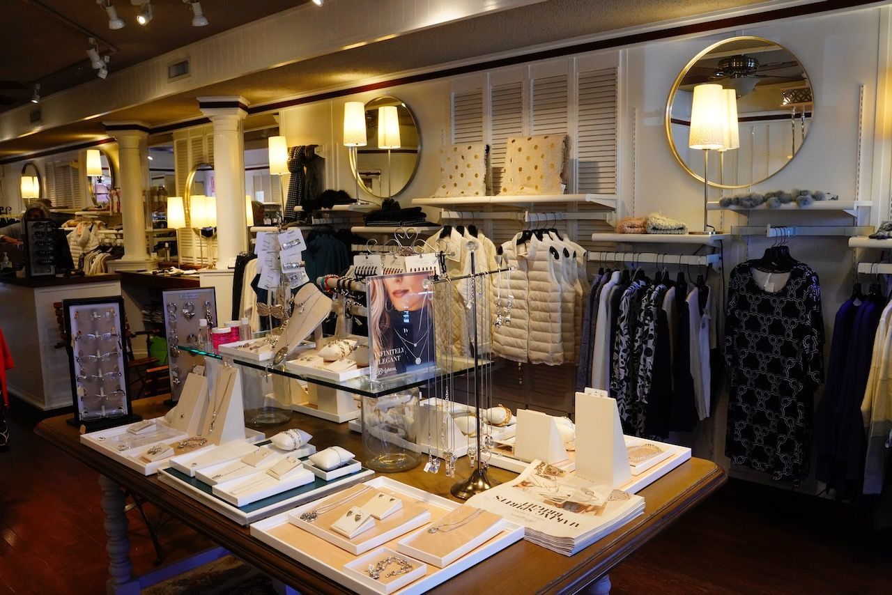 A store filled with lots of clothes and jewelry on display.