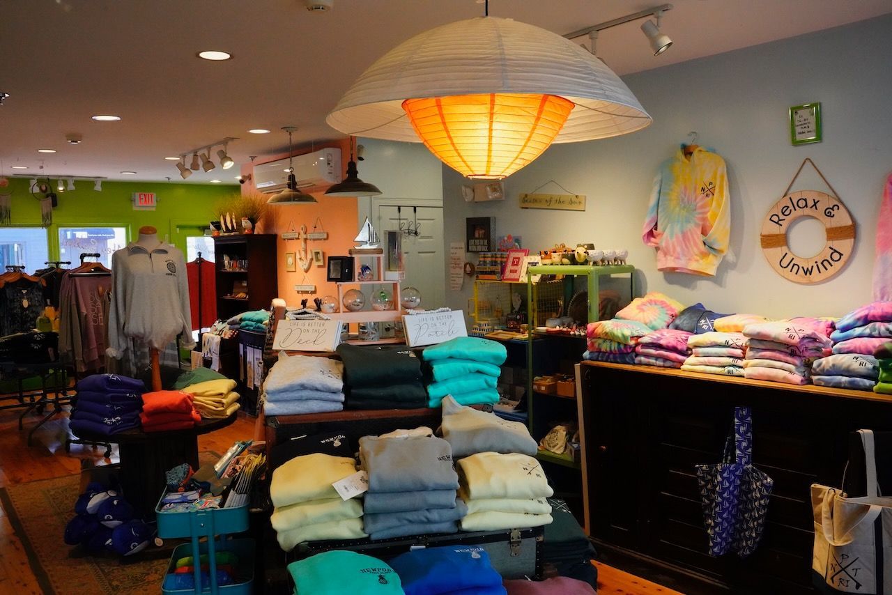 A store filled with lots of clothes and a life preserver hanging from the ceiling.