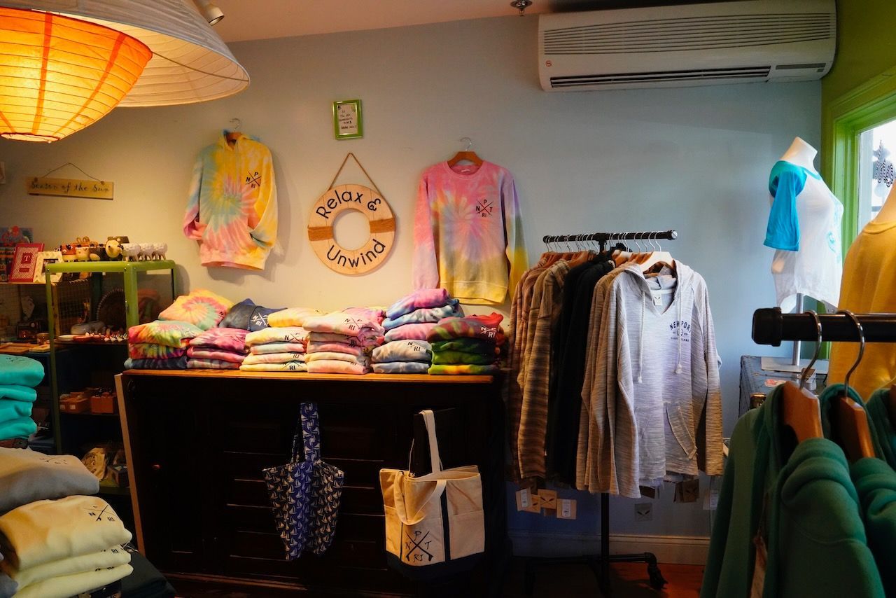 A store filled with clothes and a life preserver on the wall.