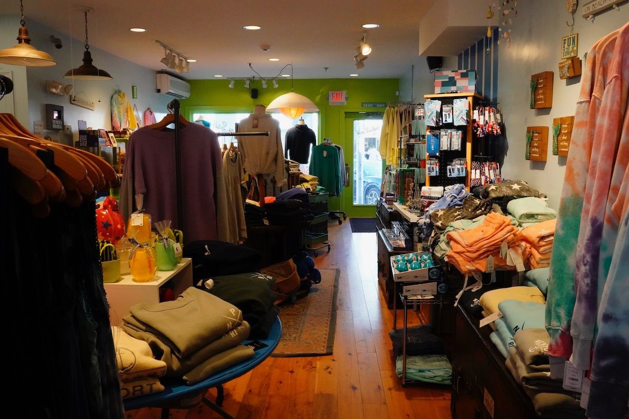 A store filled with lots of clothes including a purple shirt