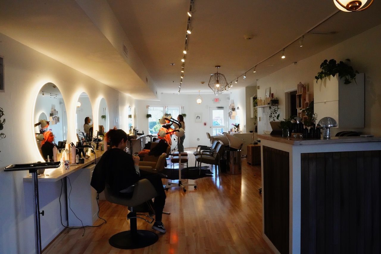 A woman is getting her hair cut in a salon.