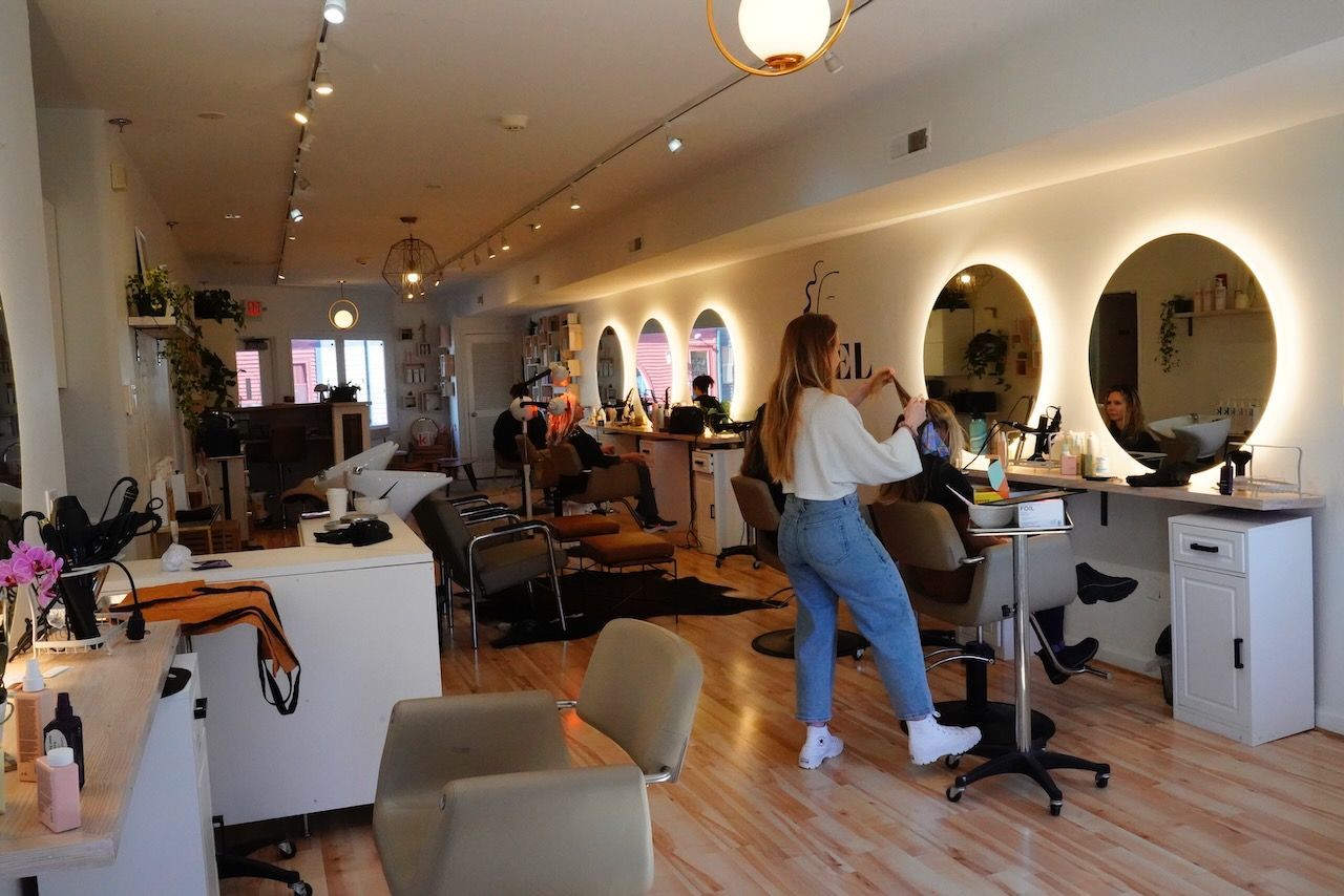 A woman is getting her hair cut in a salon.