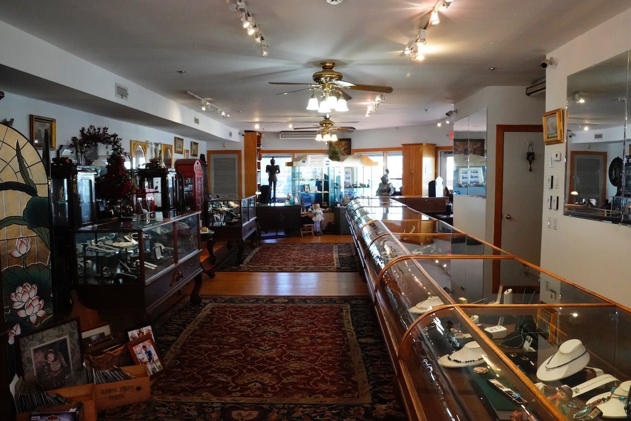 A jewelry store with lots of display cases and a ceiling fan