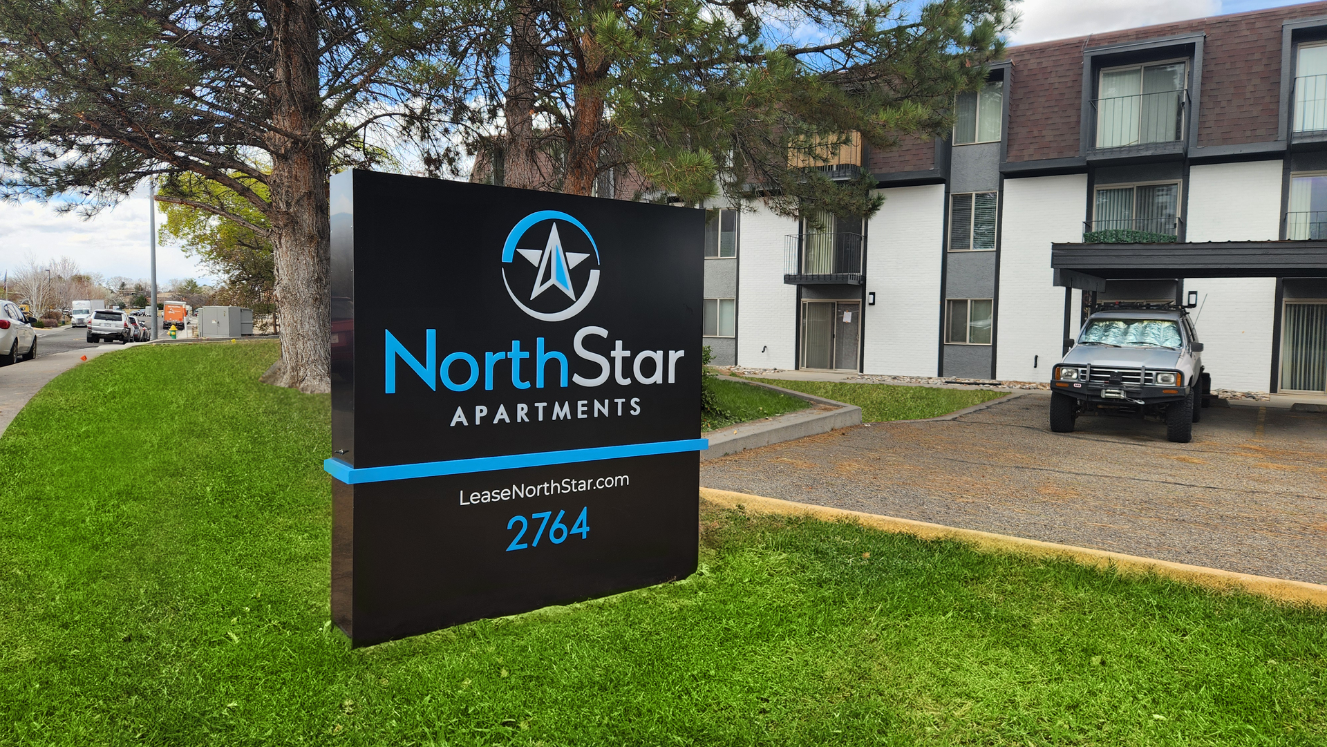 A large white apartment building with trees in front of it