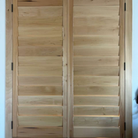 Two wooden interior window shutters with horizontal slats installed in a frame against a white wall.