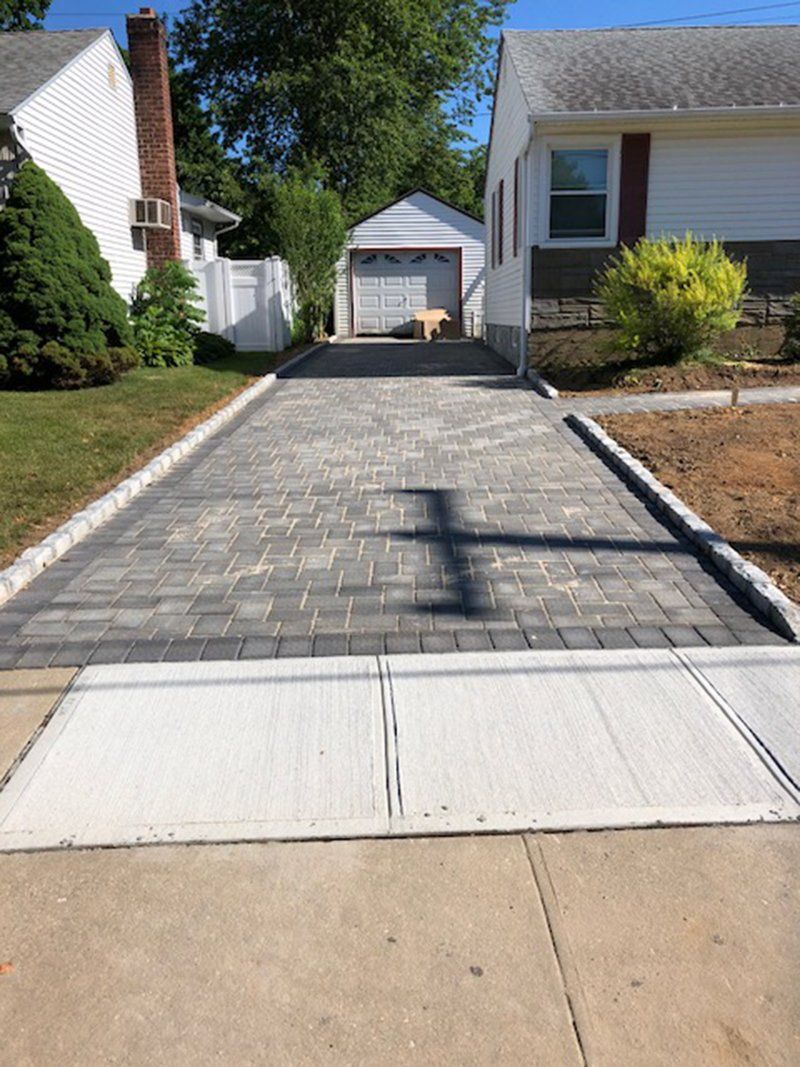 grey stone driveway with grey brick  fence