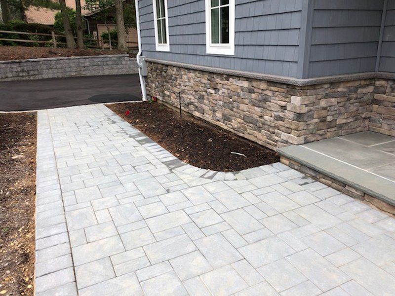 front walkway of a house with grey rectangular bricks