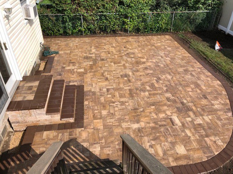 Steps made of brown bricks leading into the patio made of many light brown bricks