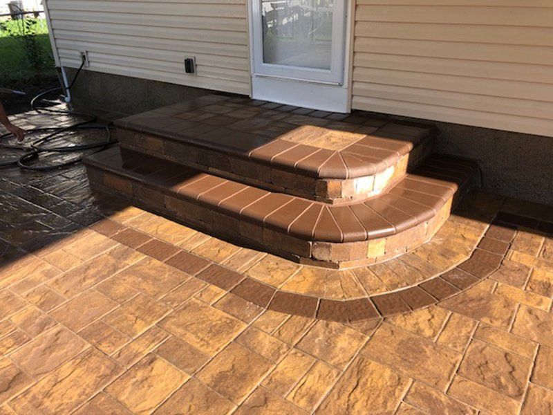 stoop made from light and dark brown bricks leading to the back door of a house