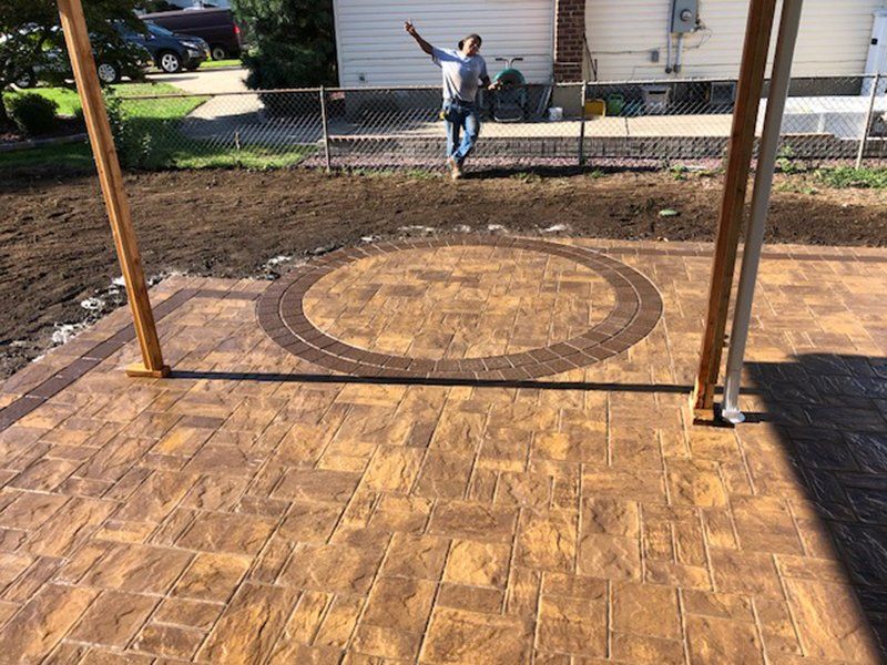 patio made of brown and dark brown bricks with a circle design in the patio