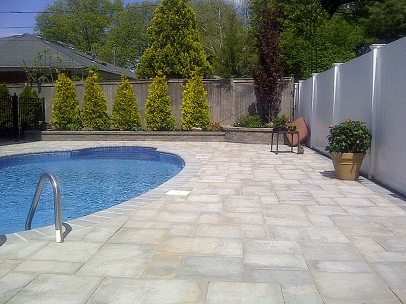 A in ground pool with grey bricks for patio