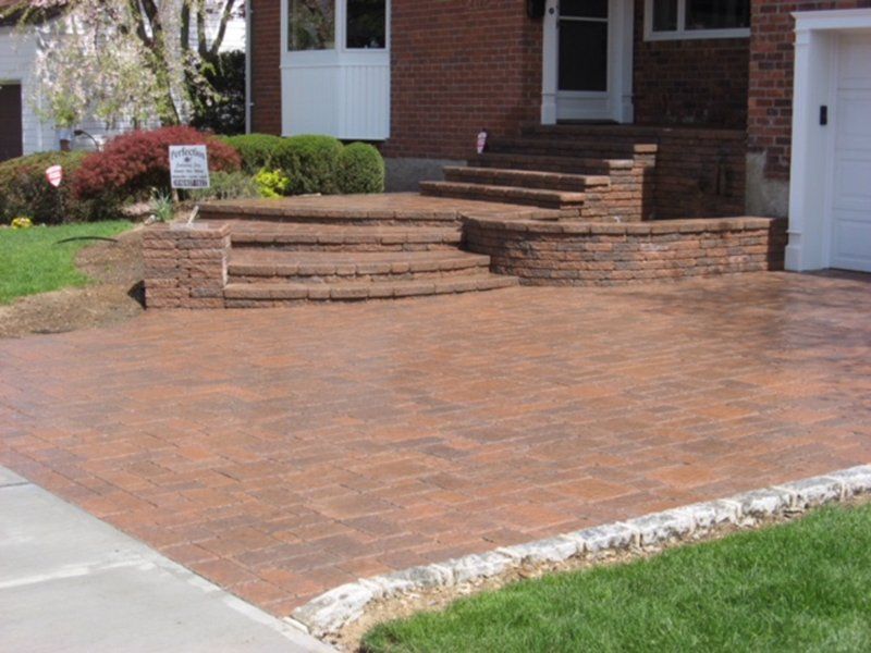 red stone stoop with multiple steps leading to stone driveway