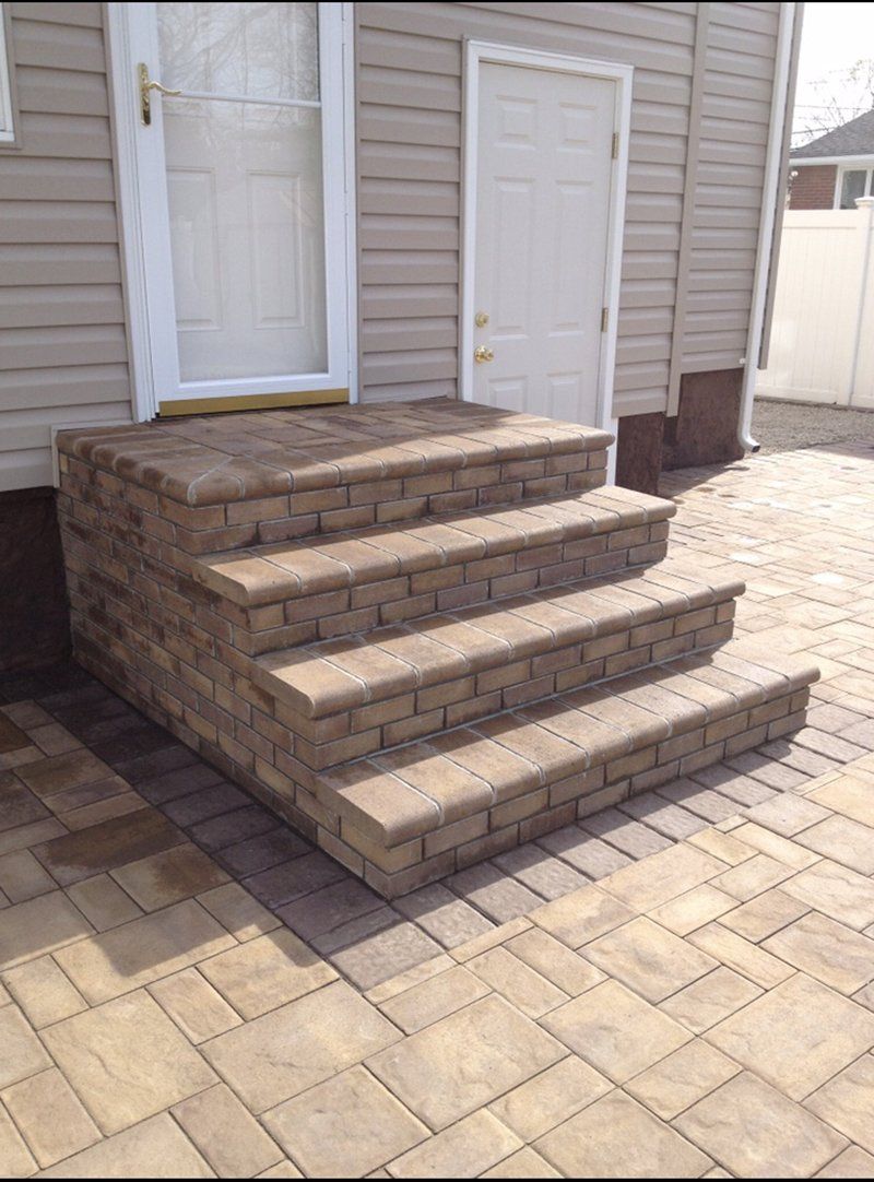 red stone stoop leading to stone patio in rear of house
