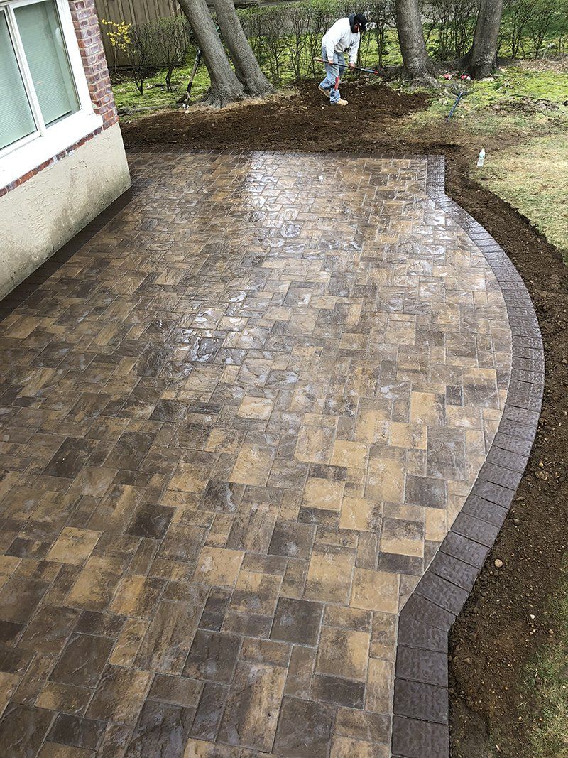 rear of house showing light grey stone patio with a dark grey  stone frame around it