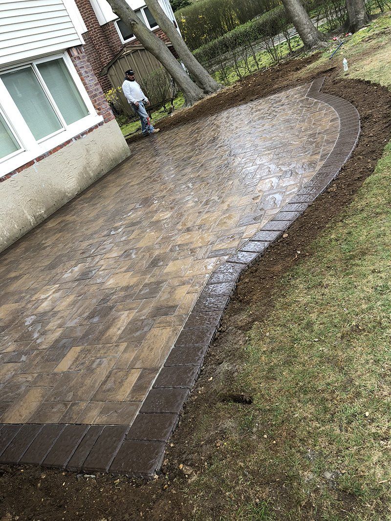 rear of house showing light grey stone patio with a dark grey  stone frame around it