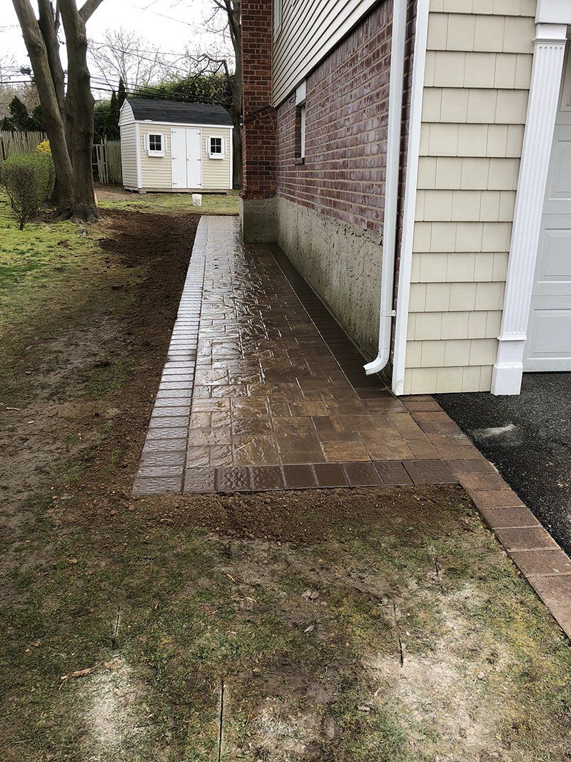 wet light brown stone walkway on side of house