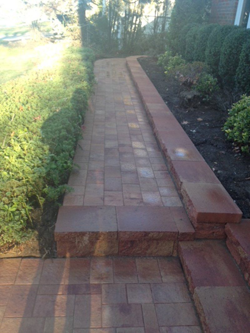 red brick walkway by front yard of home