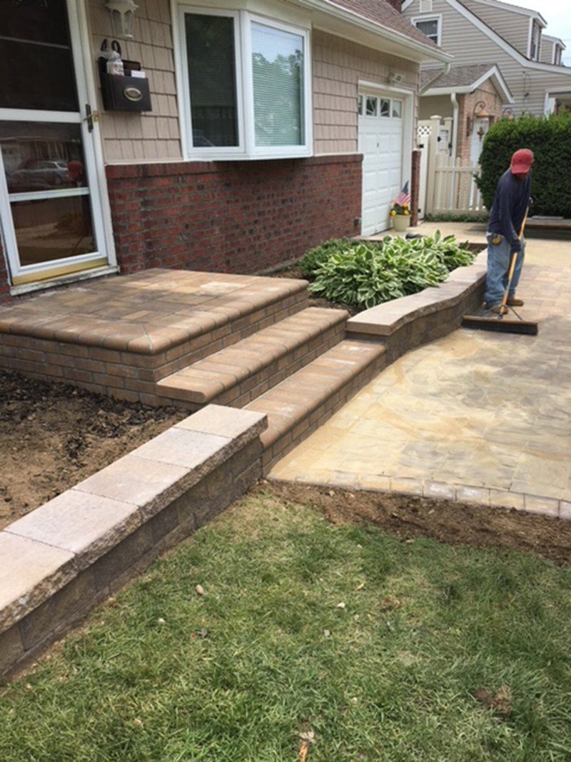 brown brick stoop leading to the brown stone brick driveway