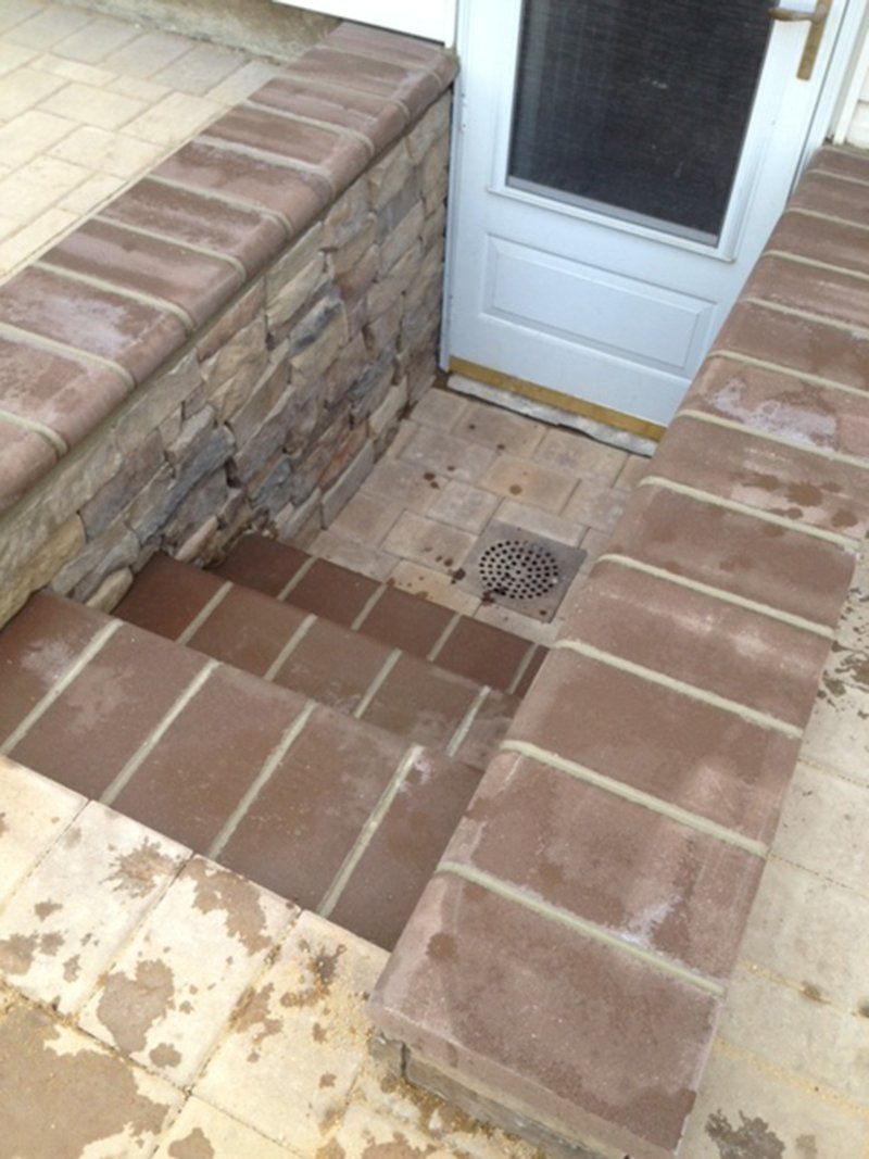 brown stone brick steps leading into basement  door