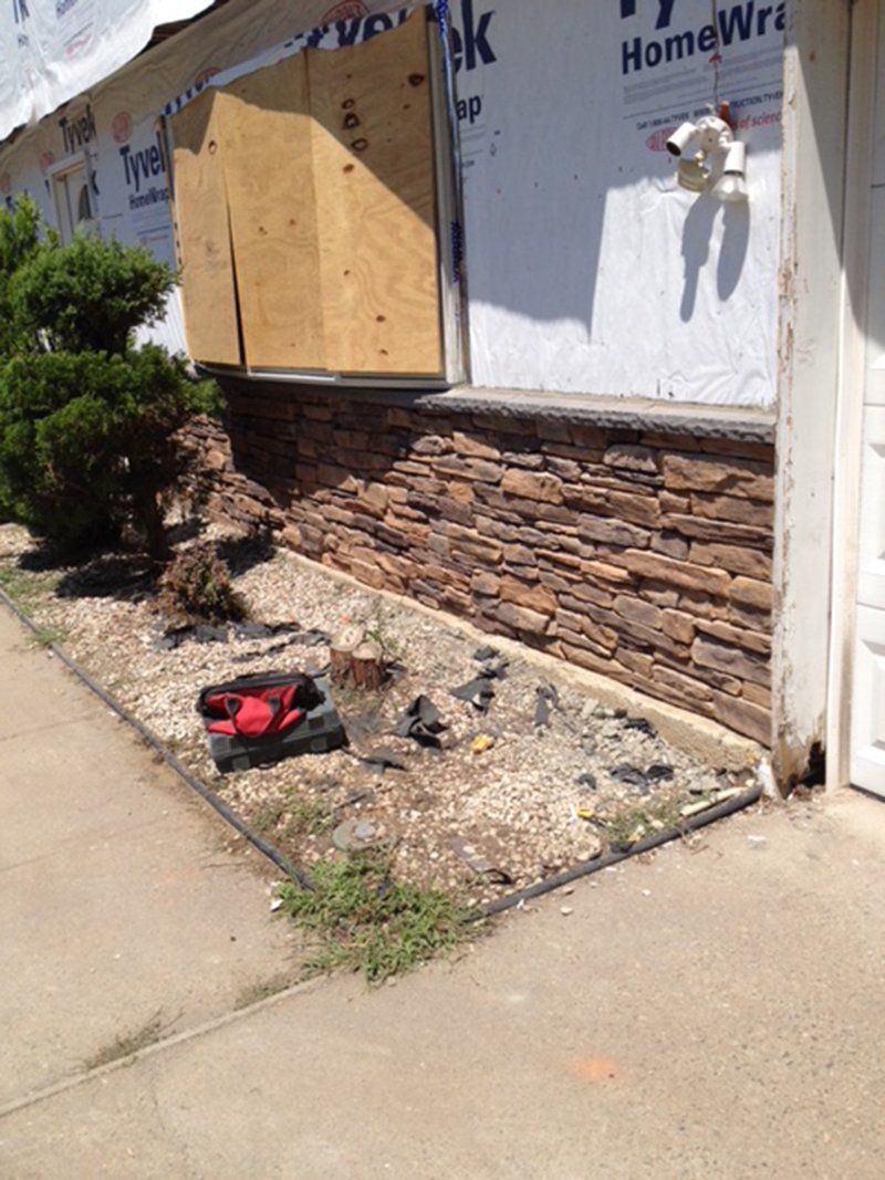 bottom half of front of home covered by red stones along the wall