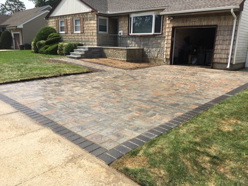 front of house with steps leading into walkway to the driveway, made of small stones