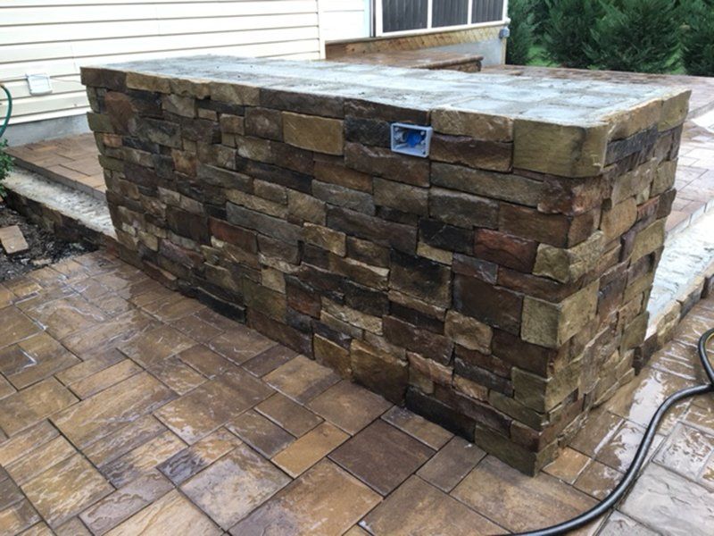 a stand alone wall made of multiple dark colored stones