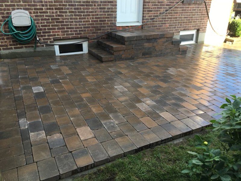 dark brown stone patio with stoop at the back of the house