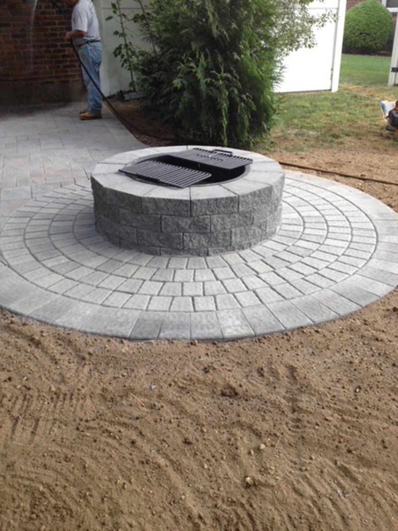 round grey stone fire place with a grey stone rings around fire place