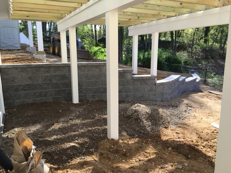 low tiered grey stone fence under wooden patio