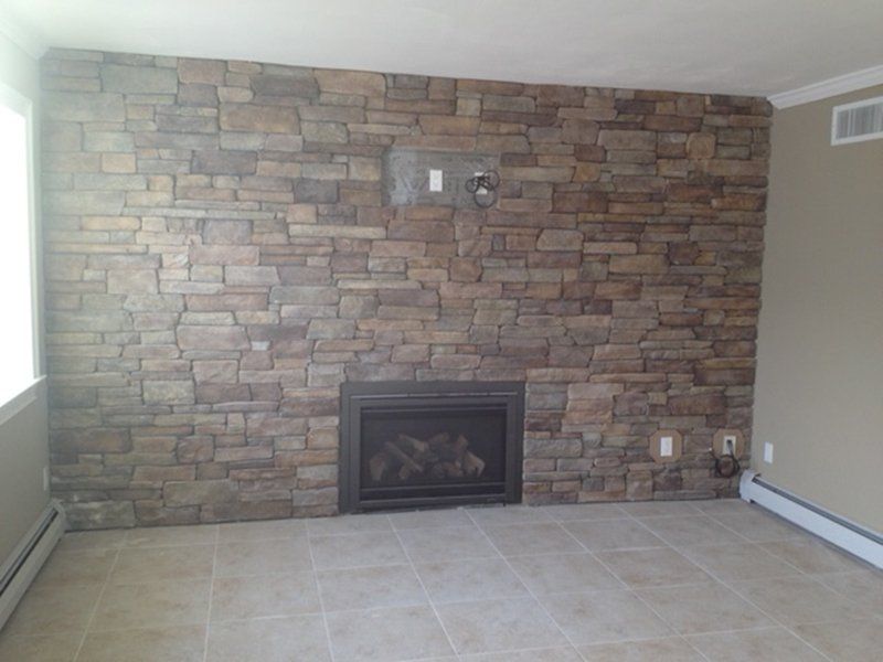 inside home fire place with multi colored stone around the fireplace wall