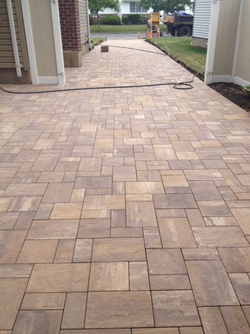 long brown brick Driveway on a sunny day