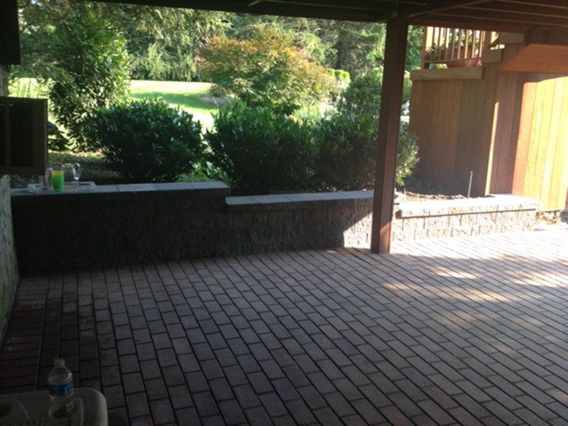 red stone patio with a low tiered stone fence