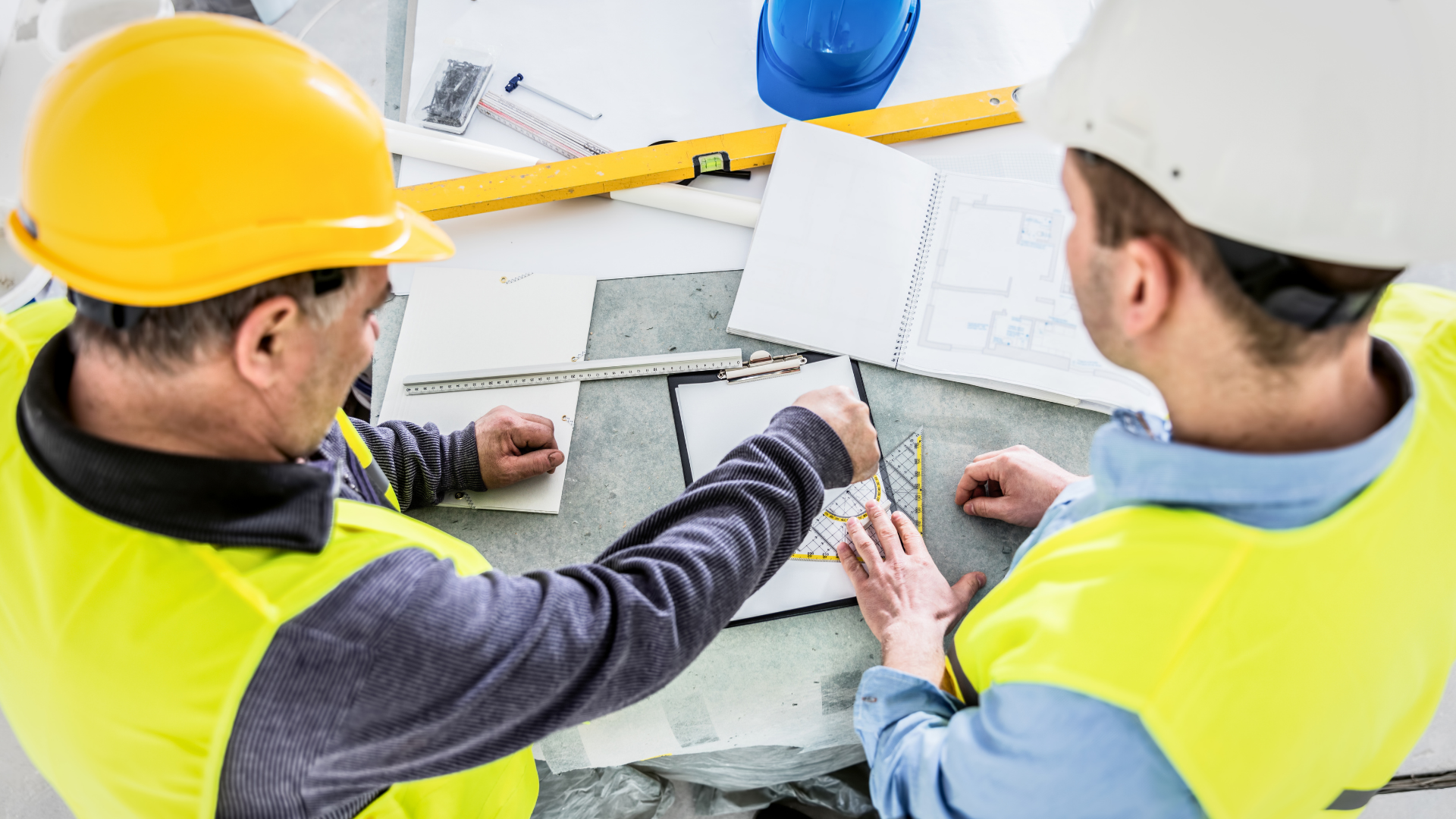White metal warehouse with blue accents and a closed garage door, under a cloudy sky.