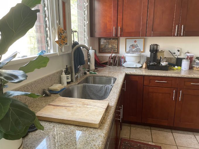 A kitchen with two sinks and a cutting board on the counter