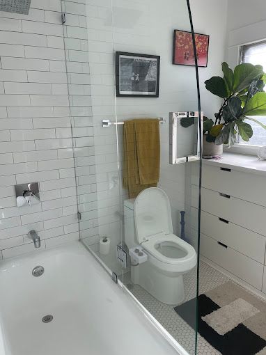 A bathroom with a toilet , tub and shower.