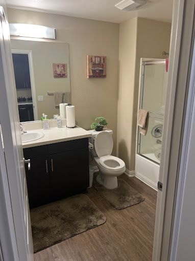 A bathroom with a toilet , sink , and shower.