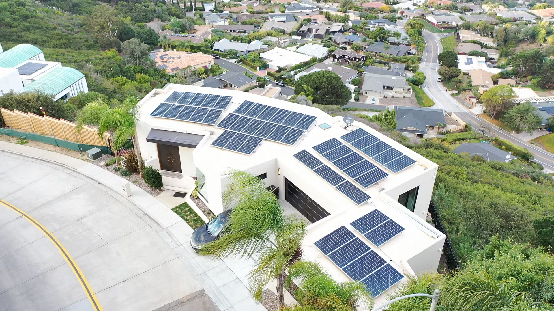 an aerial view of a house with solar panels on the roof .