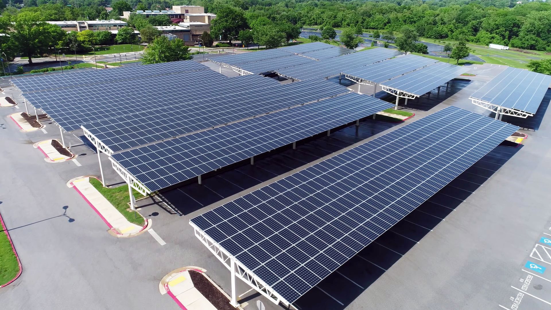 an aerial view of a parking lot with solar panels on the roof