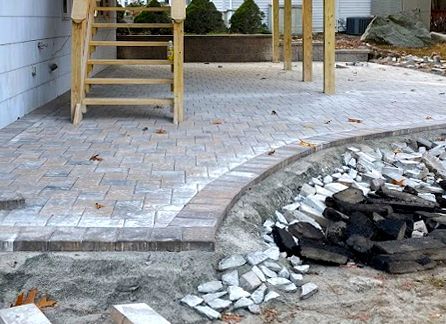 A man wearing a helmet and ear muffs is working on a tree stump.