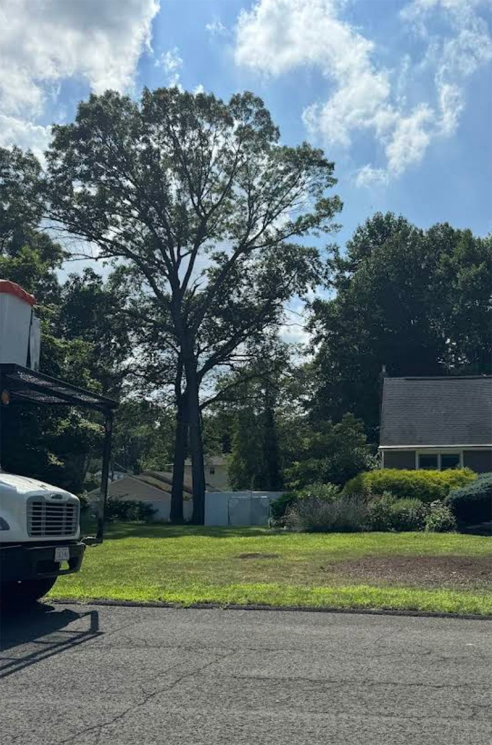 A white truck is parked in a driveway in front of a house.