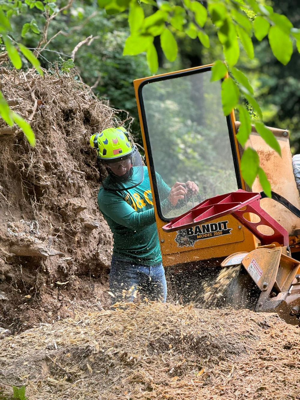 A man is cutting a tree stump with a machine.