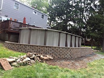 A man is climbing a tree in front of a house.