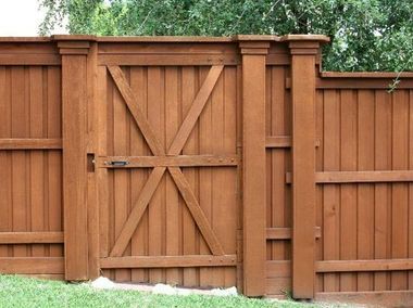 A wooden fence with a gate in the middle of it