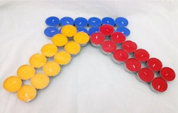 Red yellow and blue candles arranged in the shape of an arrow