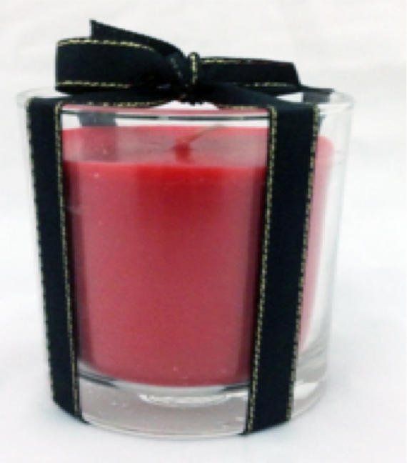 A red candle in a glass with a black bow