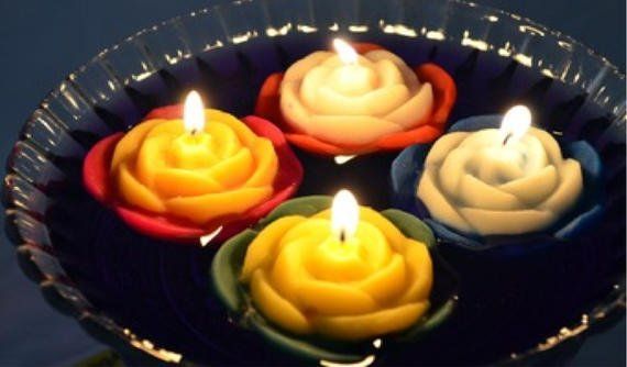 Four candles in the shape of roses are on a plate