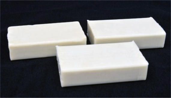 Three pieces of white soap on a black surface