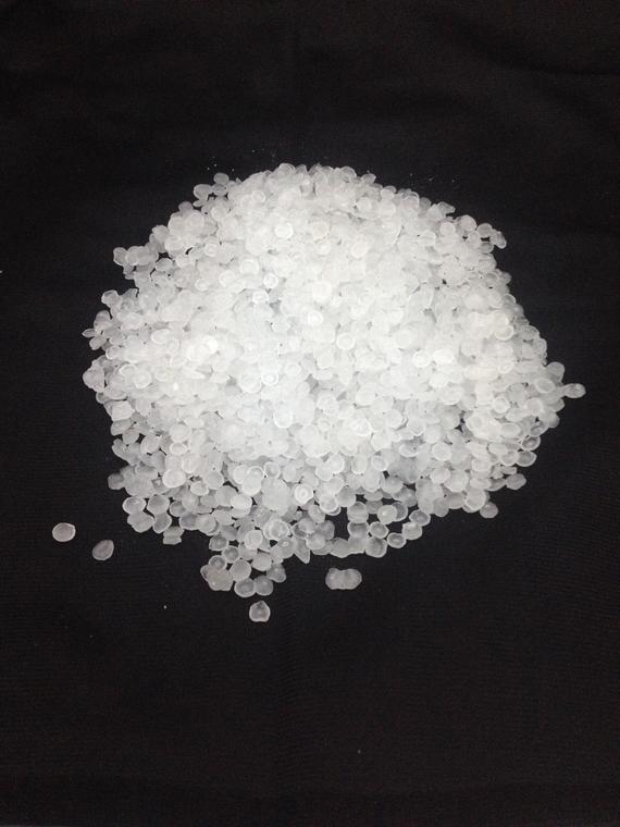 A pile of white beads on a black surface