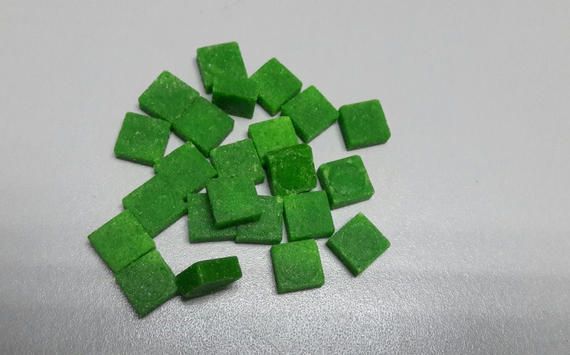 A pile of green squares on a white surface